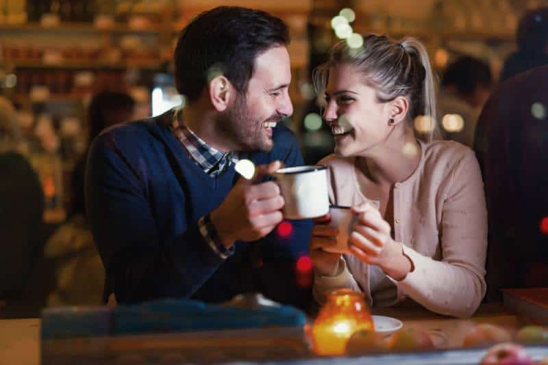 un couple heureux qui parle au bar et qui a un rendez-vous