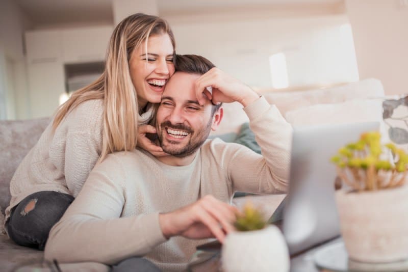 Un couple souriant assis à la maison