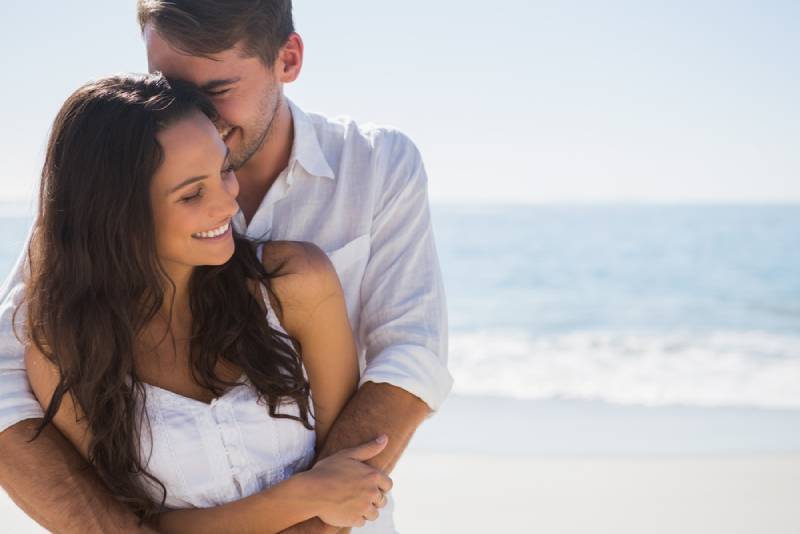 Un homme embrasse sa petite amie sur la plage