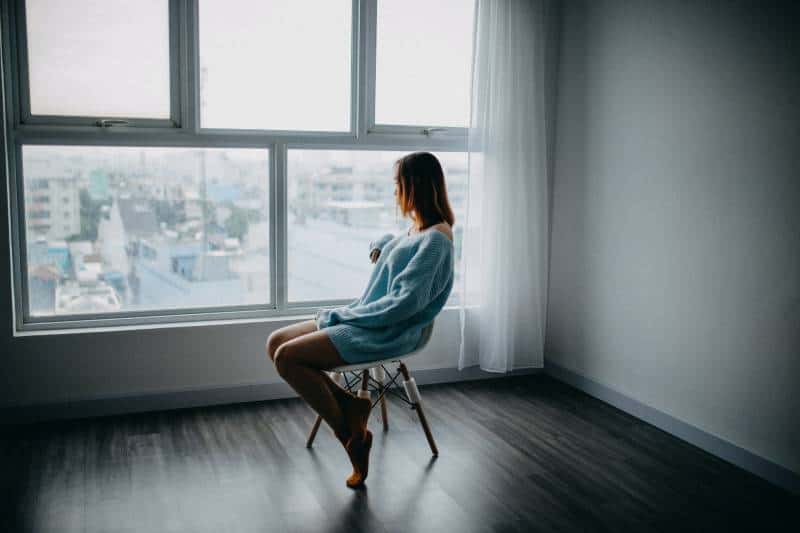Une femme inquiète, assise sur une chaise à la maison