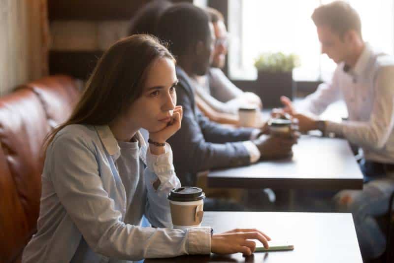 Une fille bouleversée assise au café
