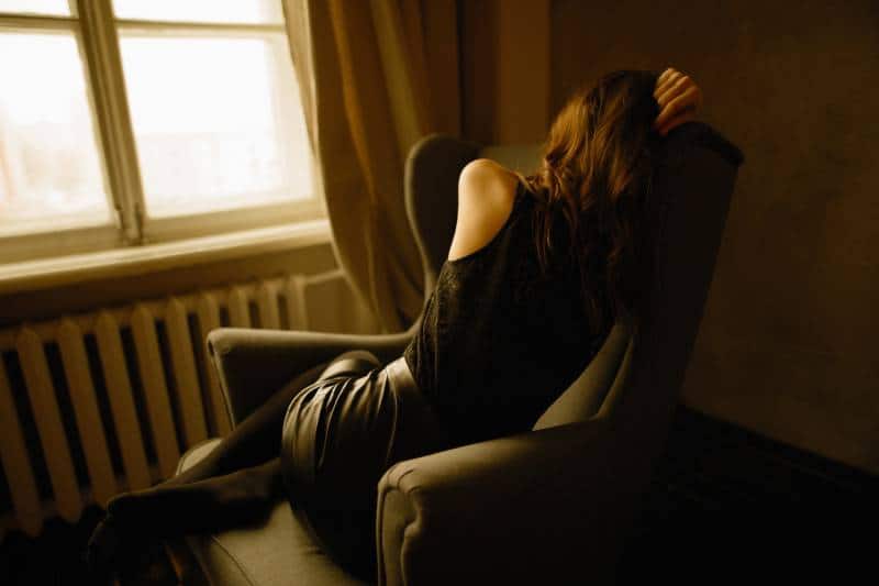 Une fille inquiète assise sur un canapé