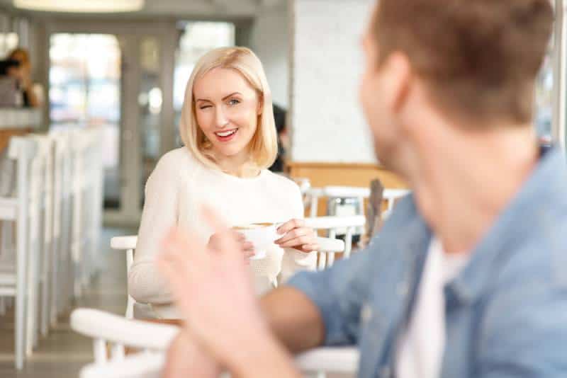femme flirtant avec un homme dans un café