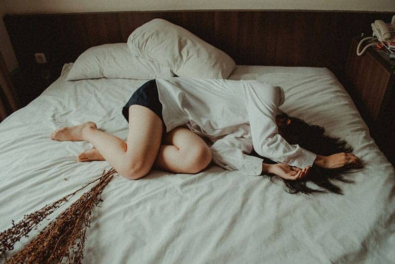 femme triste allongée sur son lit