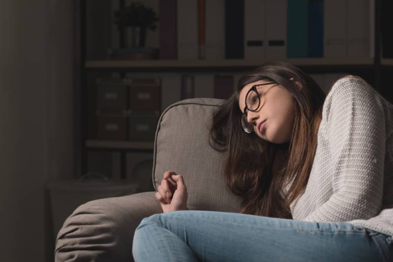 femme triste allongée sur un canapé et pensant