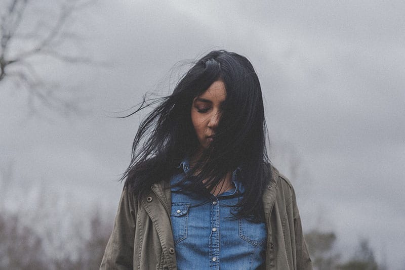 jeune femme aux cheveux noirs se tenant à l'extérieur
