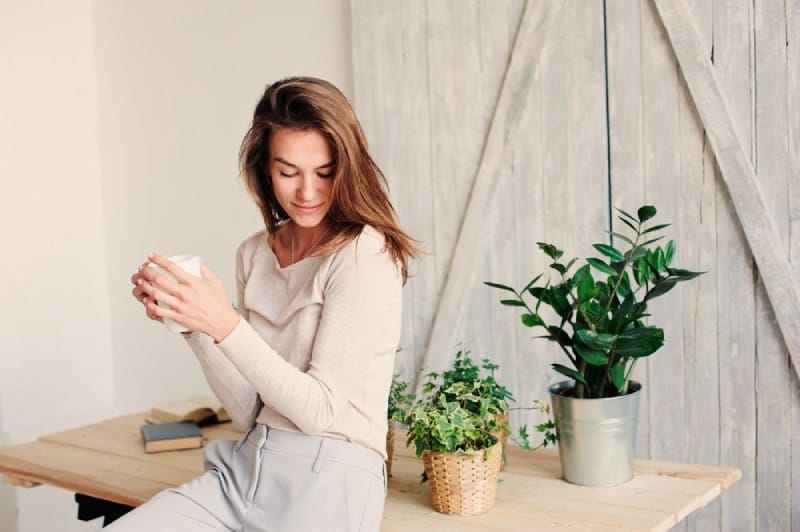 jeune femme se détendant à la maison avec une tasse de café