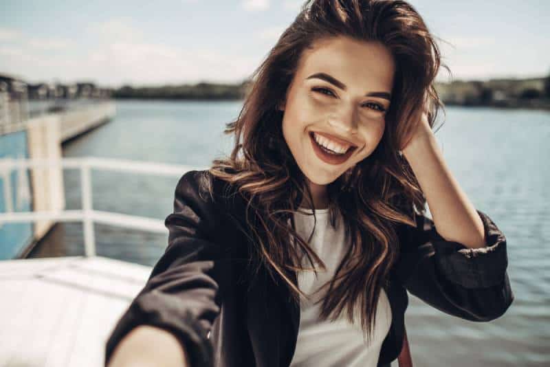 jolie femme prenant selfie près du lac