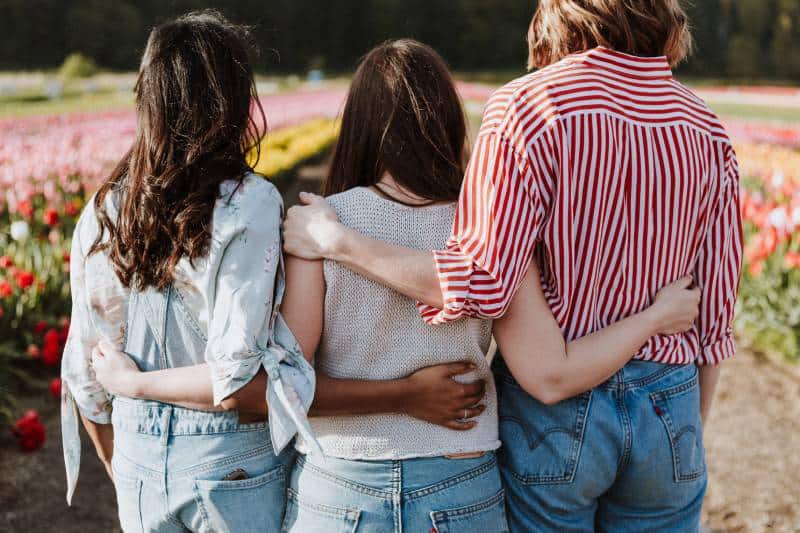 trois amies s'embrassant à l'extérieur