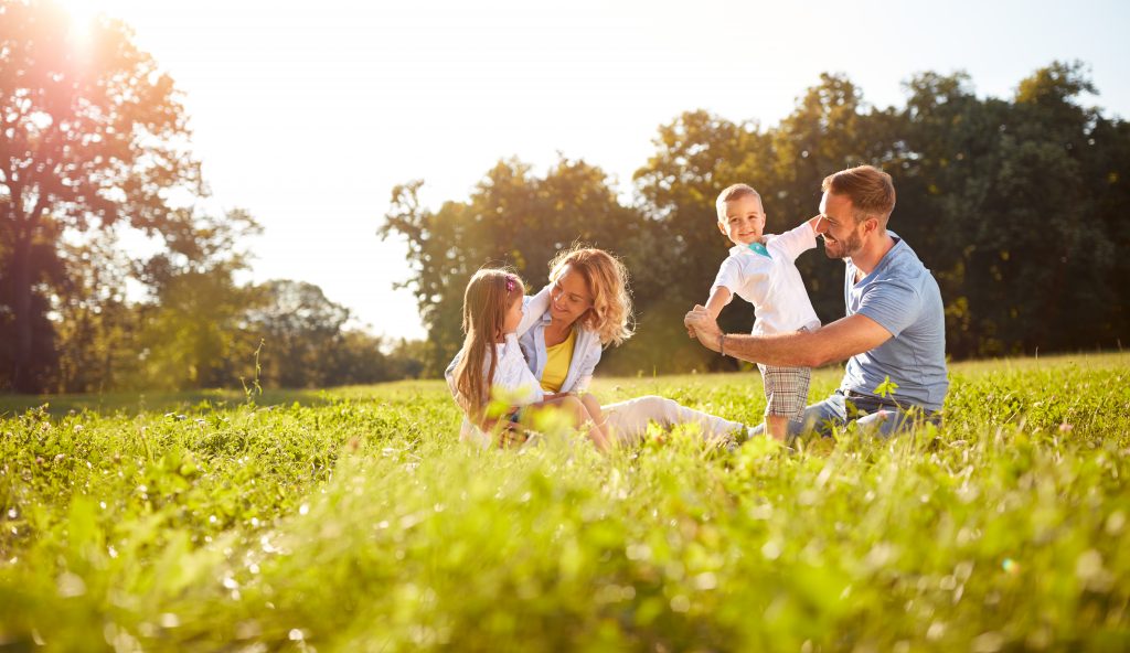 un homme et une femme avec des enfants dans un pré