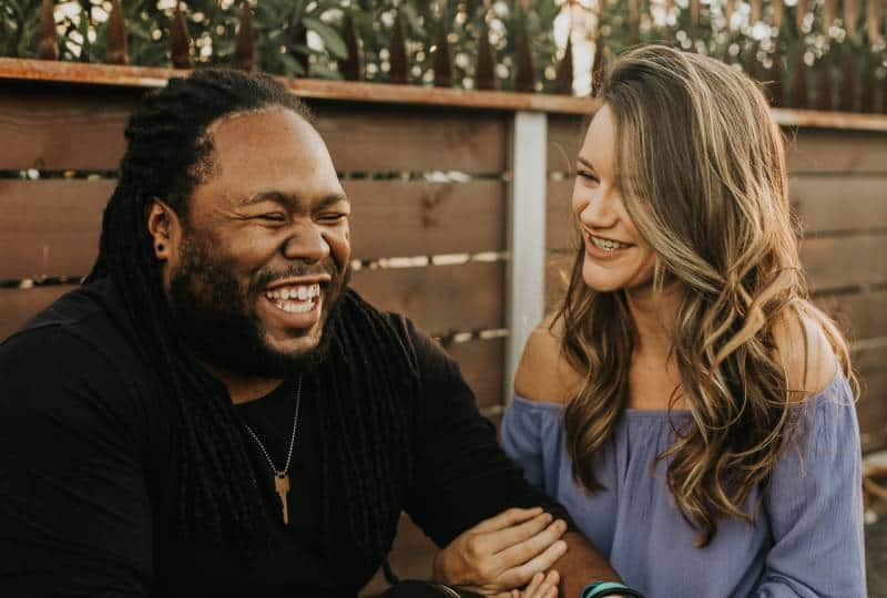un homme et une femme souriant à l'extérieur
