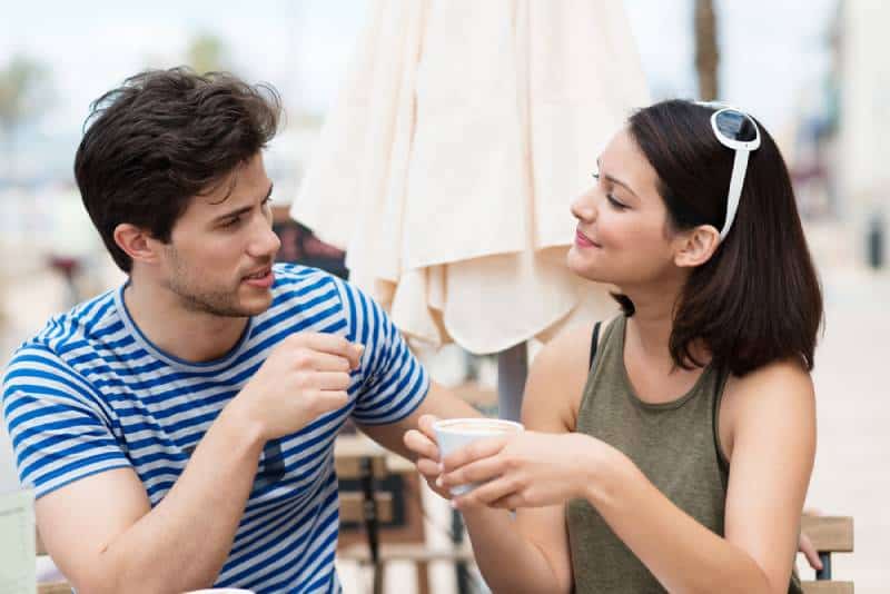 un homme parle à une femme au café
