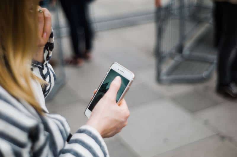 une fille qui tape un téléphone à l'extérieur