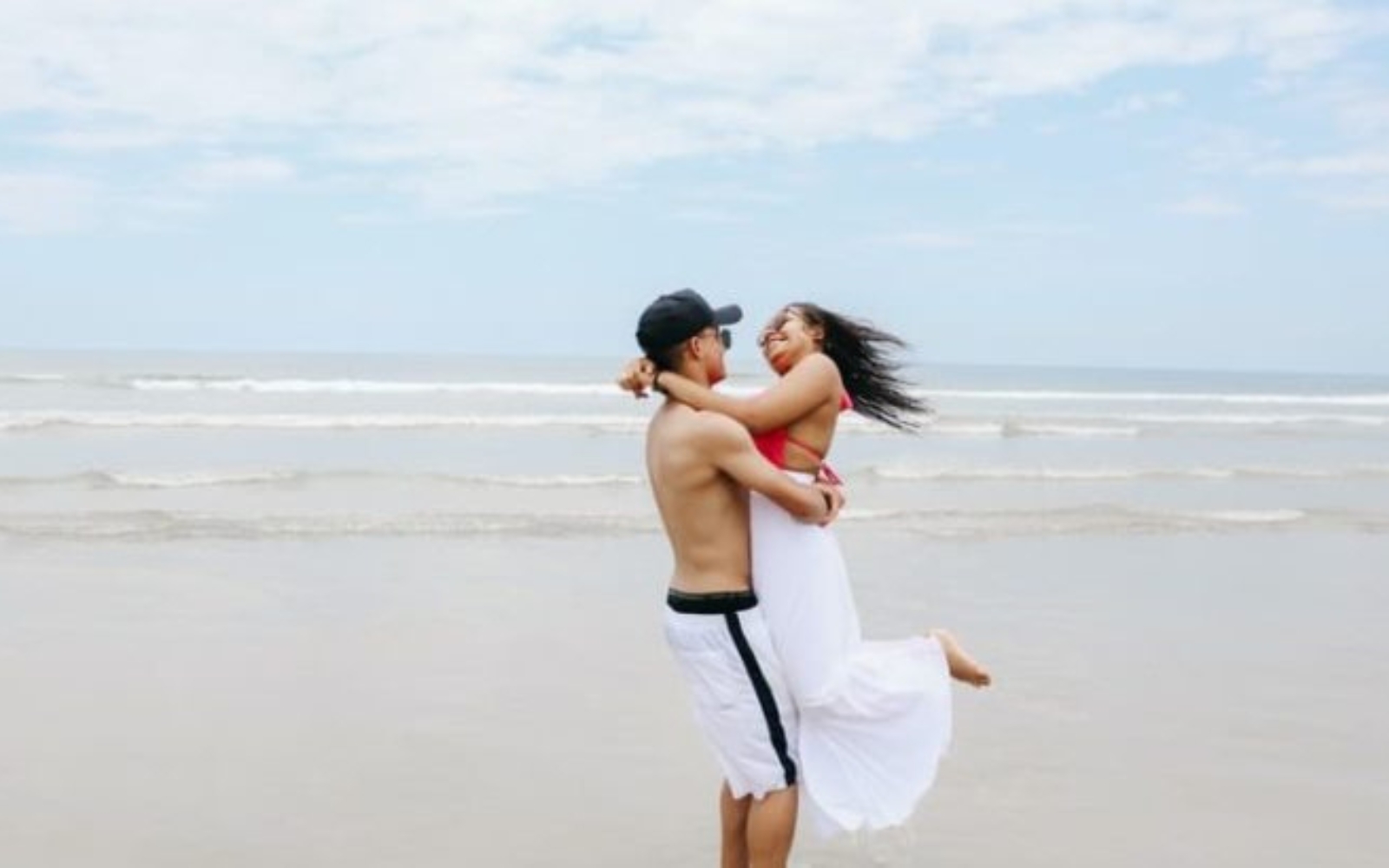 un homme et une femme embrassant sur la plage