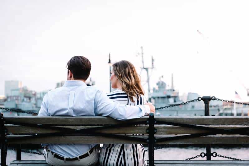 Couple assis sur un banc près de l'eau