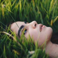 photographie de portrait d'une femme allongée sur l'herbe