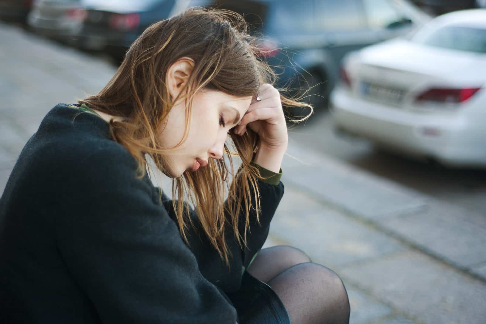 une femme avec la tête baissée est assise