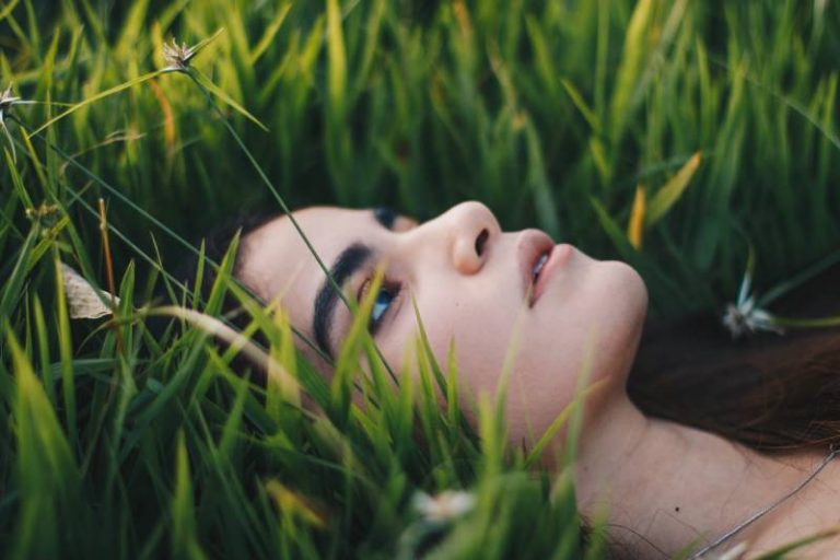 photographie de portrait d'une femme allongée sur l'herbe