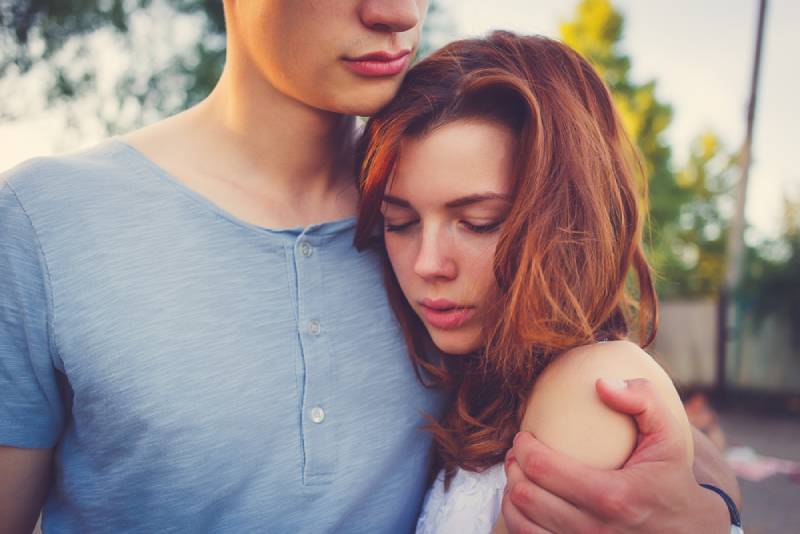 Une femme triste étreint son petit ami à l'extérieur