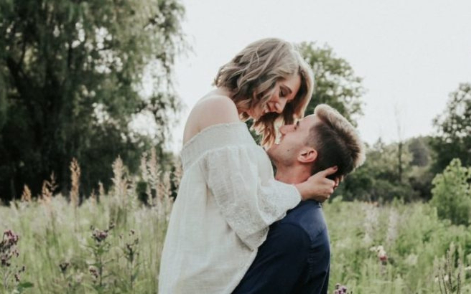 un homme et une femme sembrassant dans un champ