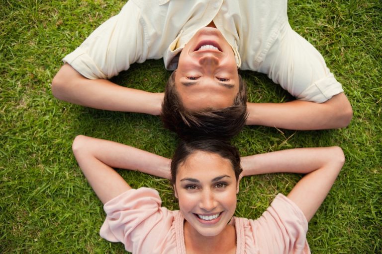 un homme et une femme heureux allongé sur l'herbe