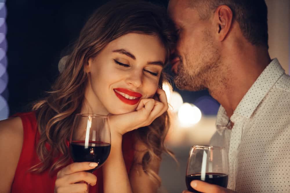 couple romantique avec des verres à vin rouges dans leurs mains