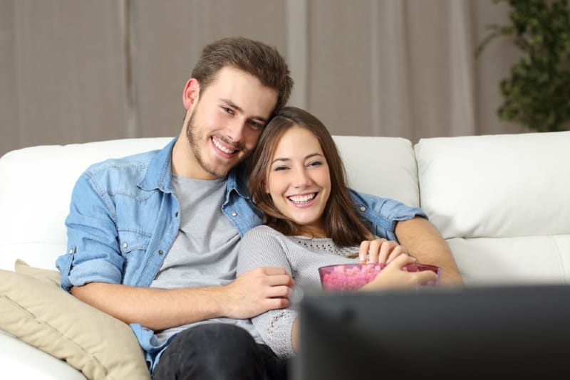 jeune couple heureux devant la télé