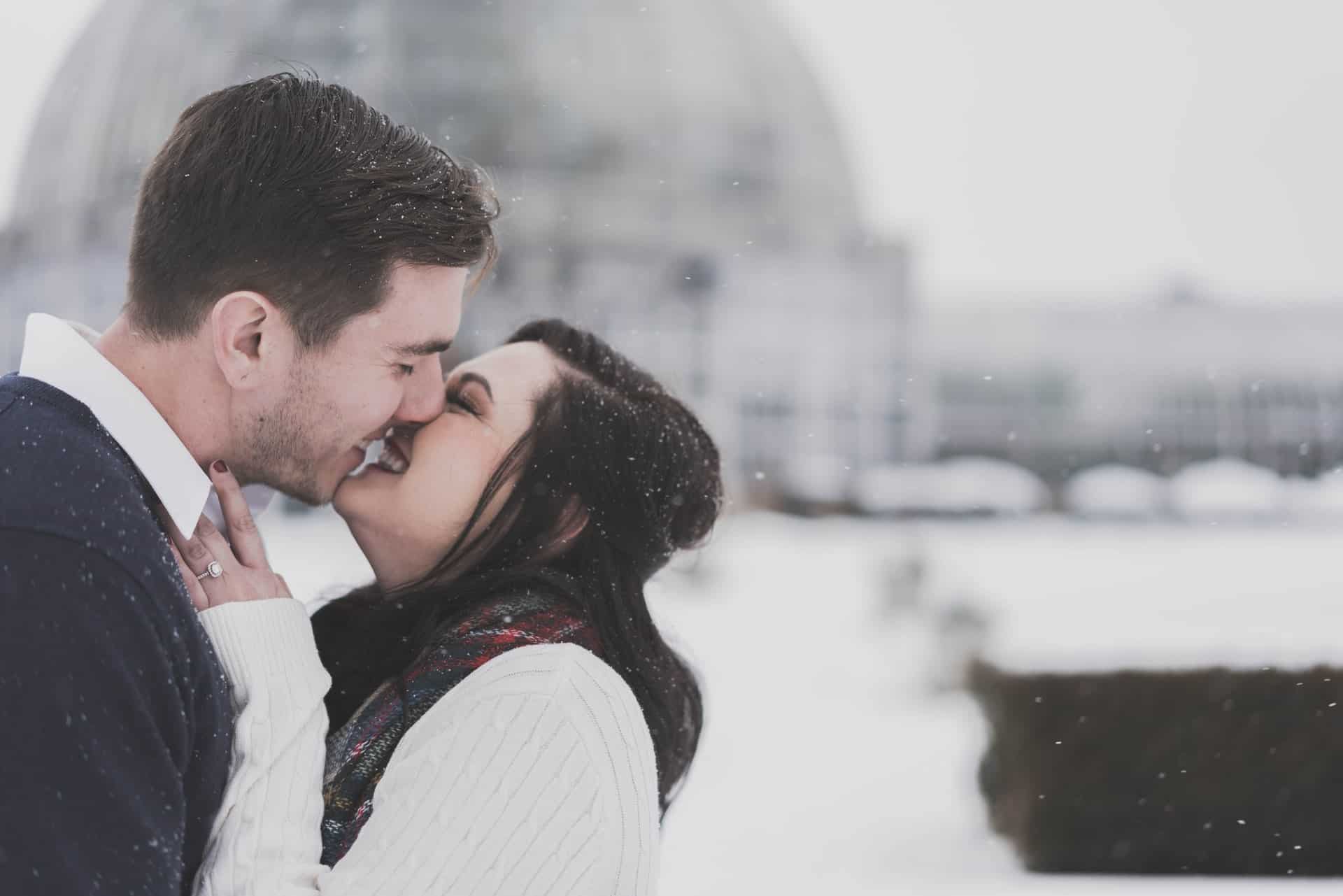 couple heureux s'embrasser dan une journée d'hiver dans la rue