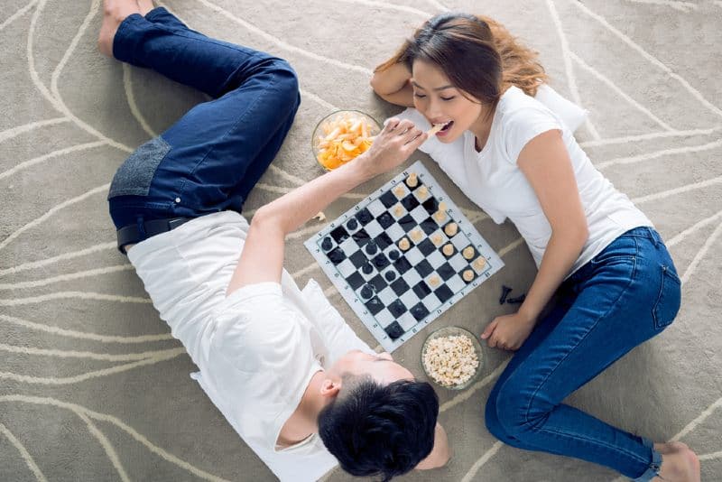 un couple asiatique jouant au jeu de société sur le sol