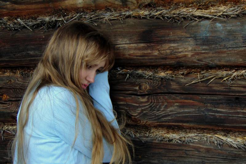 femme appuyée sur un mur de bois noir