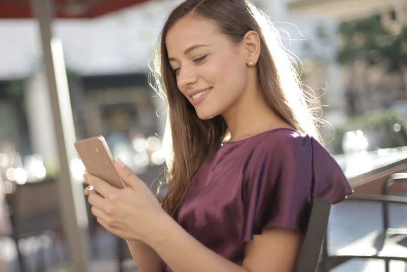 femme heureuse écrire un message sur un téléphone