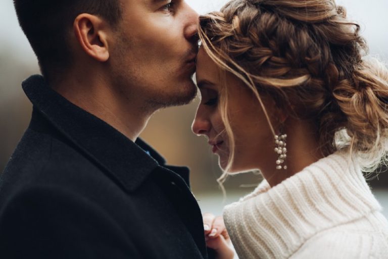 Un homme tenant une femme et embrassant son front