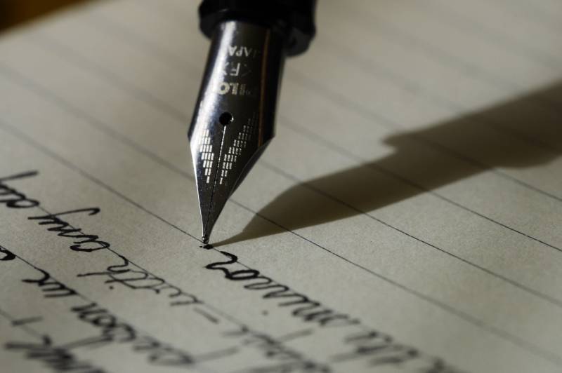 stylo plume sur papier ligné noir