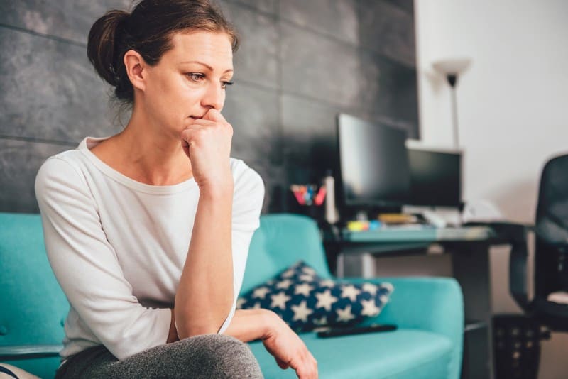 triste femme assise sur un canapé