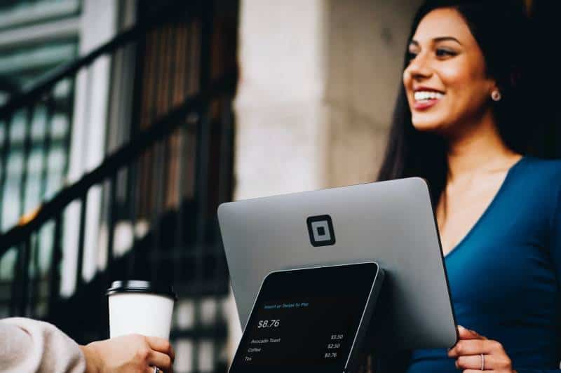 écran d'ordinateur gris et femme souriante avec un client