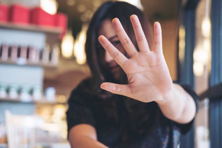 femme montrant son signe de la main couvrir son visage pour dire non à quelqu'un