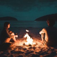 un homme et une femme assis au coin du feu