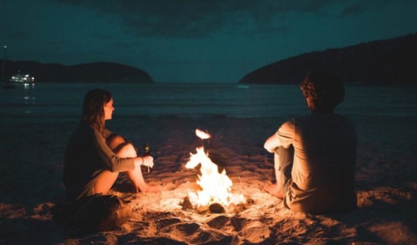 un homme et une femme assis au coin du feu