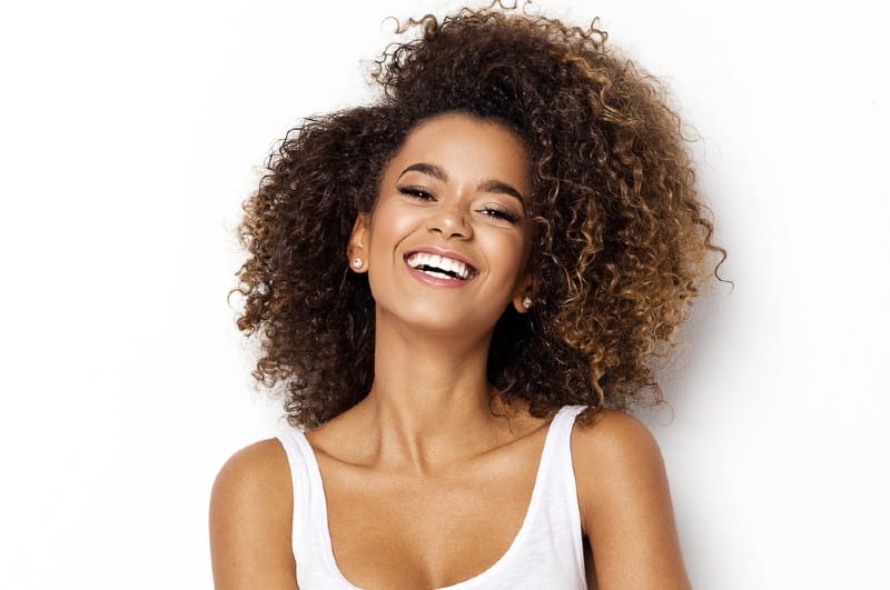 Belle fille afro-américaine avec une coiffure afro souriant