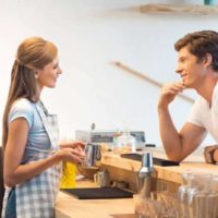 Vue latérale d'un jeune homme et d'une jeune femme flirtant dans un café