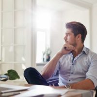 Un homme d'affaires réfléchi, assis dans son bureau à domicile.