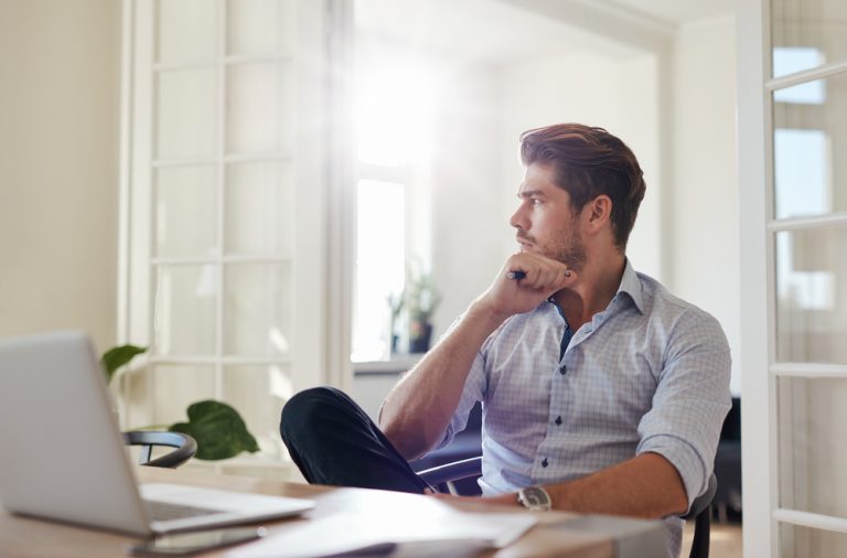 Un homme d'affaires réfléchi, assis dans son bureau à domicile.
