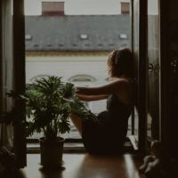 Une femme s'appuie sur la porte et regarde dehors