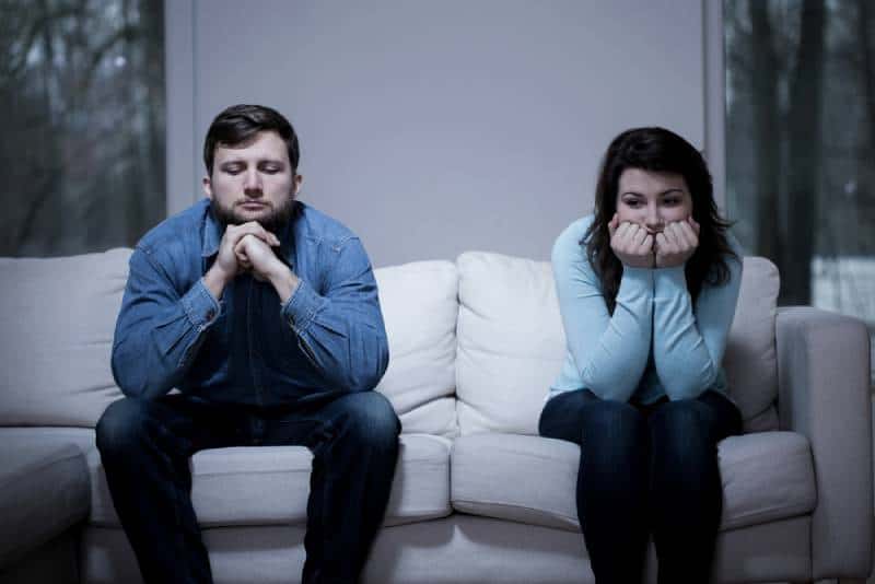Couple assis sur le canapé après une dispute