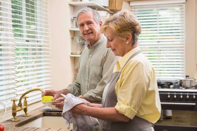 Couple de personnes âgées faisant la vaisselle à la maison dans la cuisine