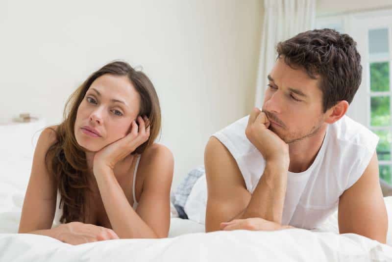 Couple malheureux allongé sur le lit