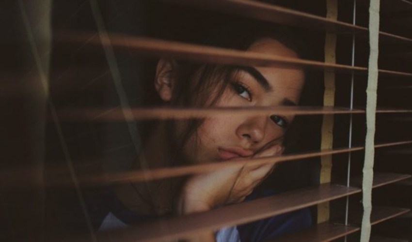 une femme appuyee contre une fenetre