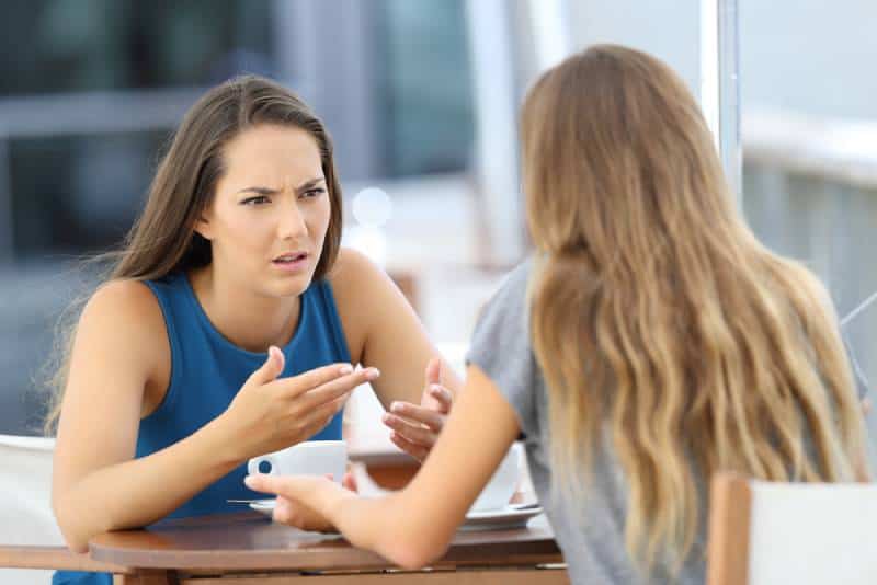 Deux filles en colère qui discutent sérieusement dans un café