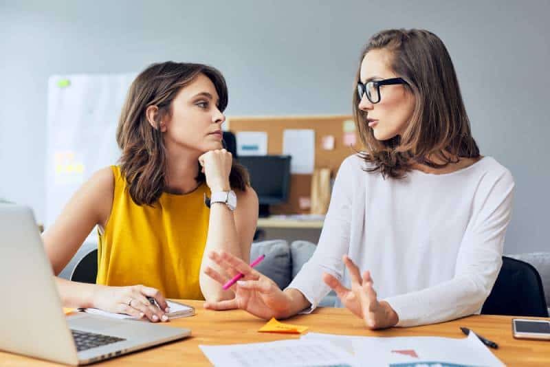 Deux jeunes collègues séduisants parlent de leur entreprise en démarrage