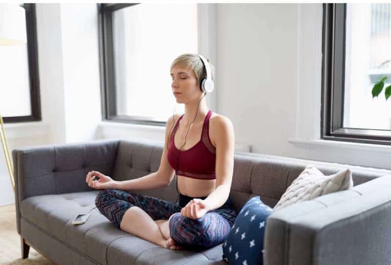 Femme écoutant une application de méditation dans le cadre de sa routine matinale de pleine conscience